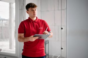 Mitarbeiter der Firma Isolierfix mit Tablet auf einer Baustelle, Businessfotos Köln
