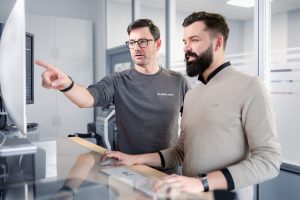 Zwei Mitarbeiter arbeiten gemeinsam an einem Computerarbeitsplatz, Businessfotografie Köln