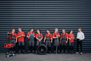 Teamfoto des Porsche-Serviceteams in Arbeitskleidung